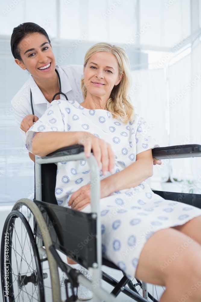 Obraz premium Doctor and patient in wheelchair smiling at camera 