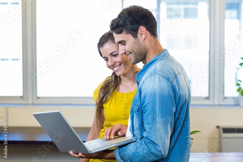 Casual business partners looking at laptop