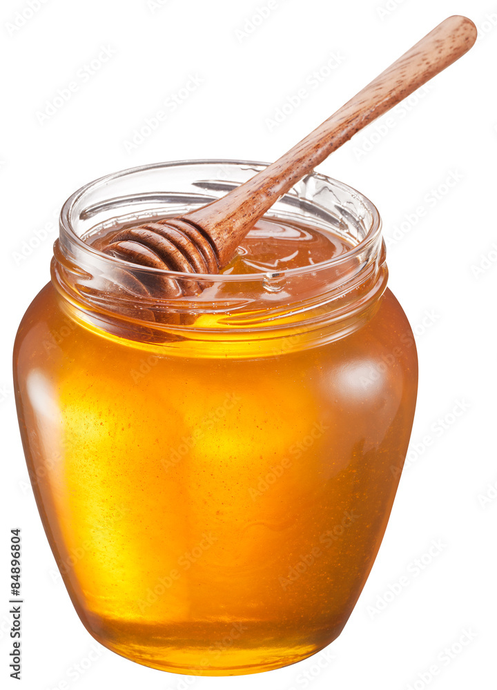 Glass can full of honey and wooden stick in it. Clipping paths. Glass can full of honey and wooden stick in it. Clipping paths.