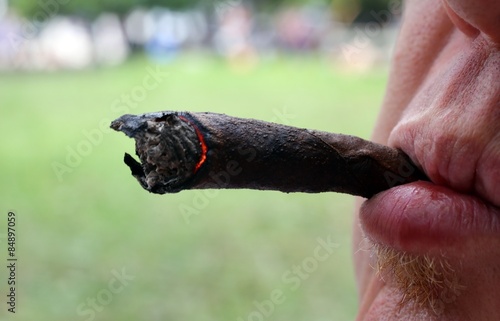 smoker with cigar in mouth and burning coals