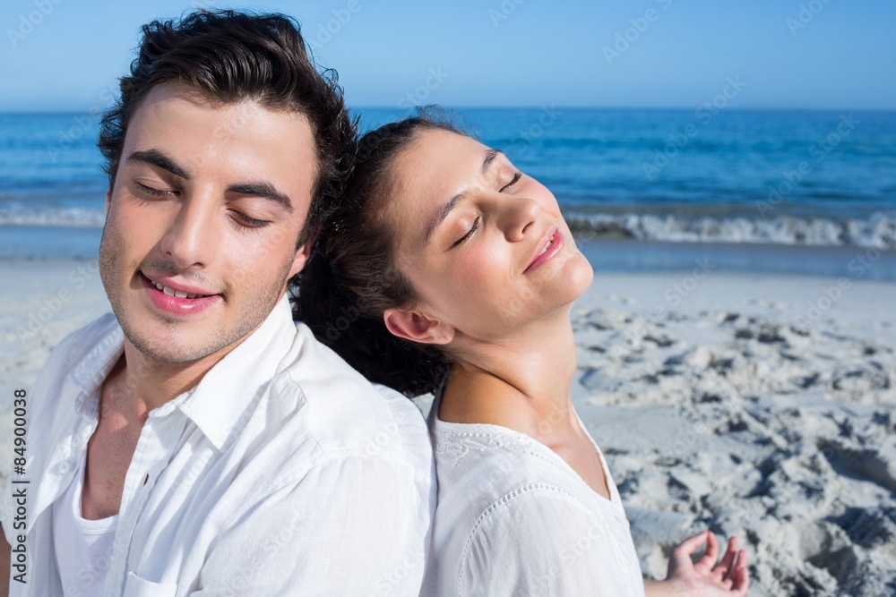 Obraz premium Happy couple doing yoga beside the water