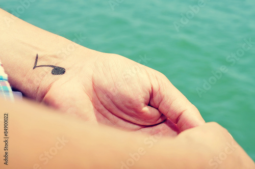 a young man with a musical note tattooed in his wrist