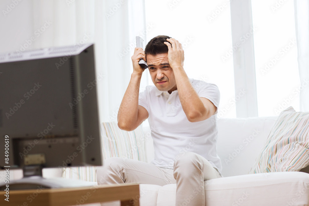 disappointed man watching tv at home disappointed man watching tv at home