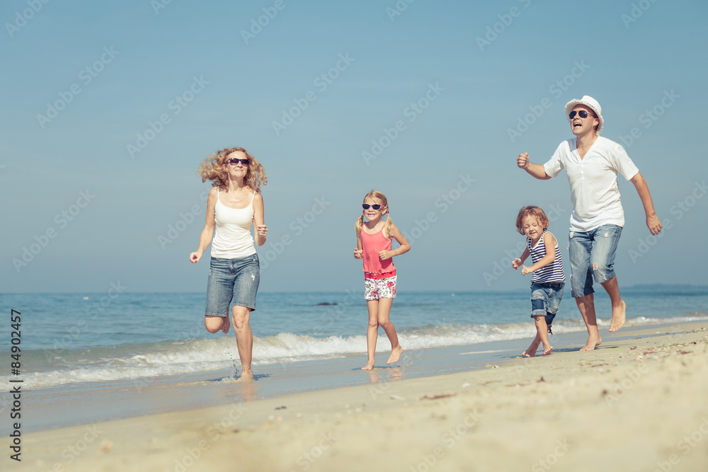 Happy family walking on the beach at the day time. Concept of fr