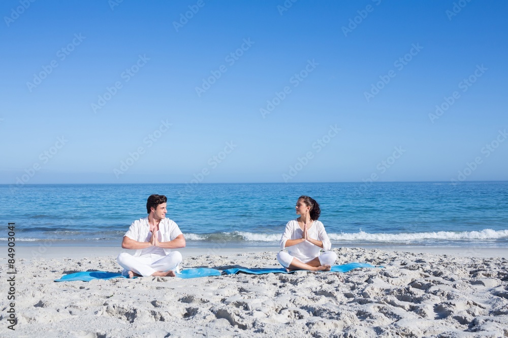 Happy couple doing yoga beside the water Happy couple doing yoga beside the water