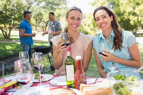 Happy friends drinking at the park 