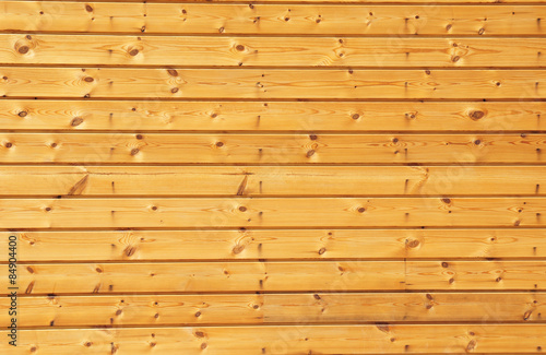 Background texture of finely slatted natural brown pine wood in a parallel pattern