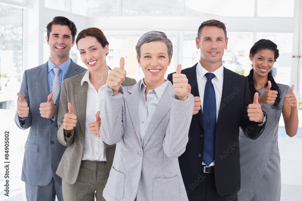 Business people looking at camera thumbs up Business people looking at camera thumbs up