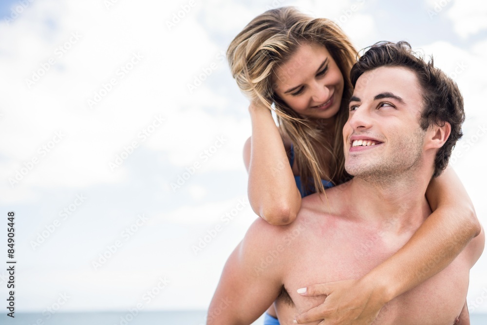 Handsome man giving piggy back to his girlfriend Handsome man giving piggy back to his girlfriend