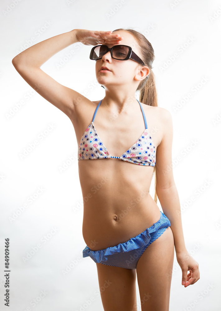 girl in swimsuit holding hand at eyes and looking up girl in swimsuit holding hand at eyes and looking up