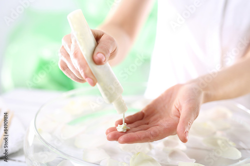 Kobieta nakłada na dłoń peeling kosmetyczny