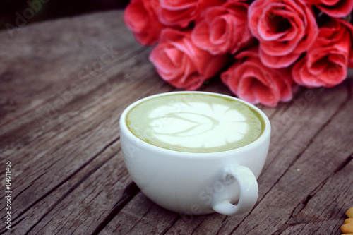 Green tea with milk and artificial flowers.