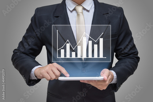 Businessman hand holding tablet graph finance on gray background