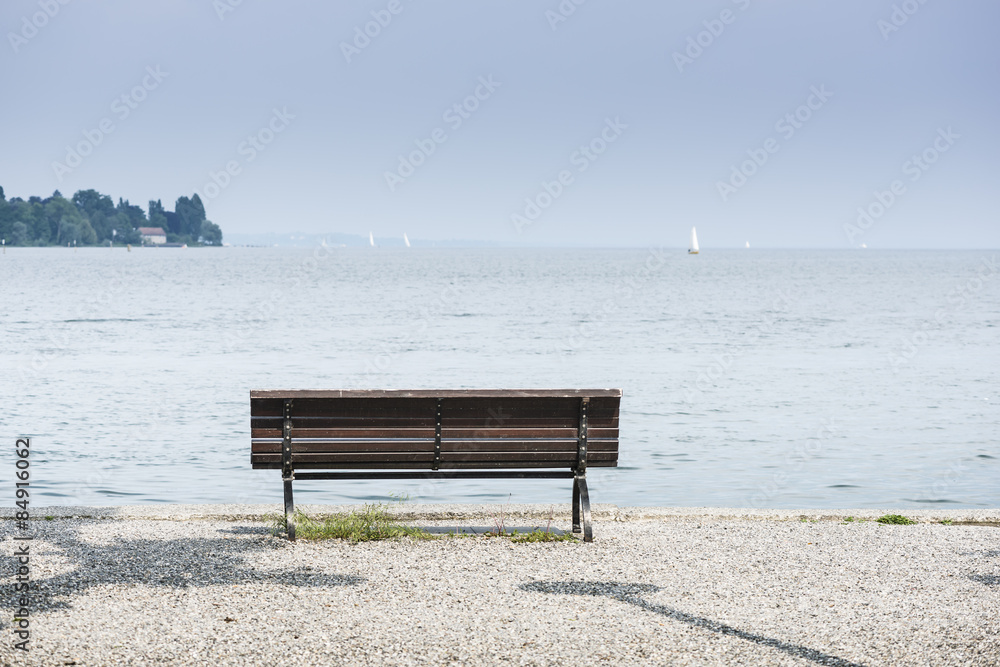 Lonely wooden bench by the lake constance  horizontal.