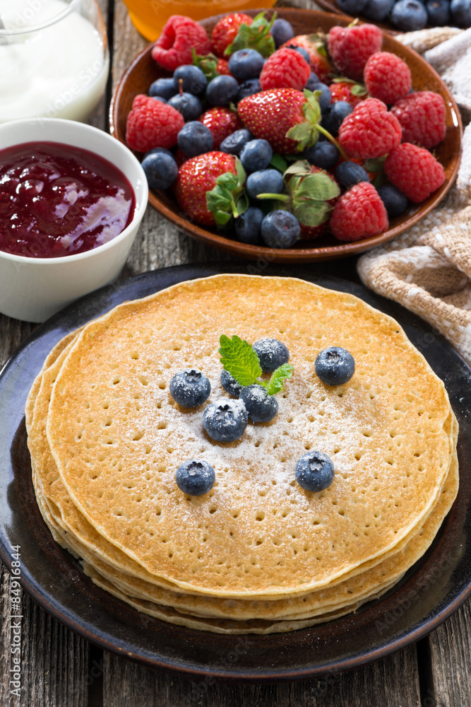 crepes, fresh berries and jams on wooden table, vertical crepes, fresh berries and jams on wooden table, vertical