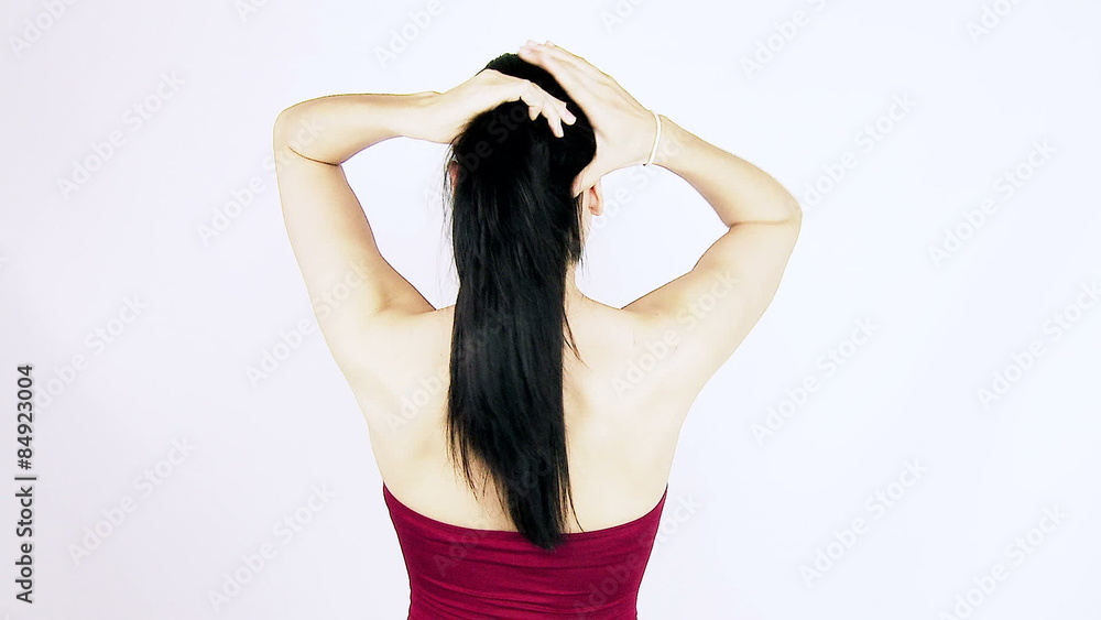 Woman doing ponytail with long black silky hair Woman doing ponytail with long black silky hair