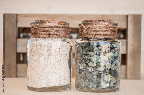 small glass jars with sand and stones from the beach