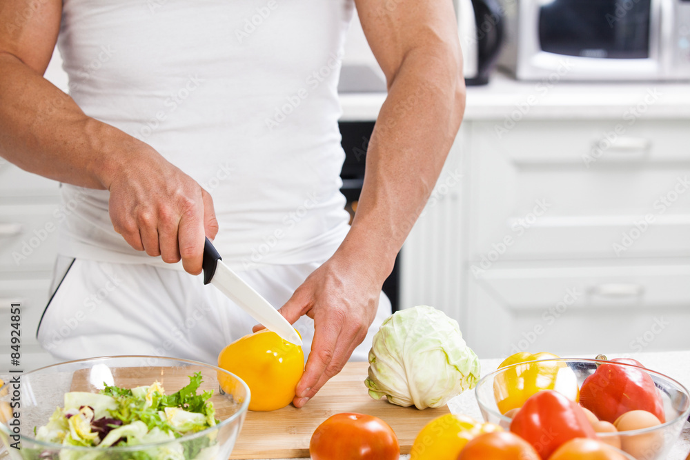 Handsome man cooking at home preparing salad in kitchen. Handsome man cooking at home preparing salad in kitchen.