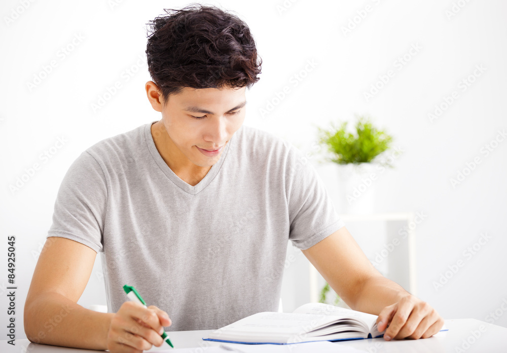 Smiling relaxed young man reading book in living room Smiling relaxed young man reading book in living room