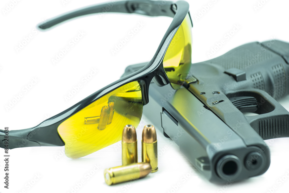 Orange sun glasses and 9mm black gun pistol isolated on white background. Orange sun glasses and 9mm black gun pistol isolated on white background.