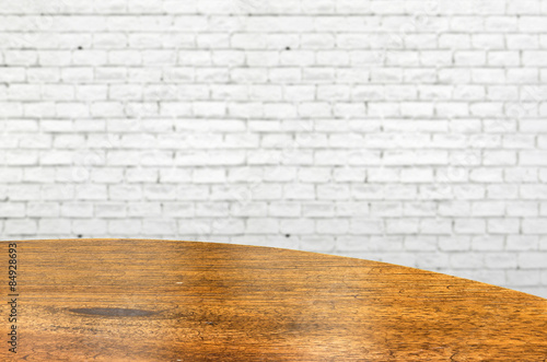 Empty wood round table and white brick wall in background. produ