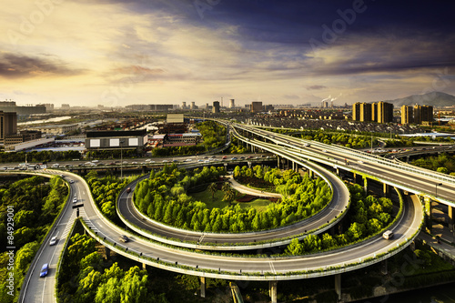Photography Elevated overpass with skyline of modern city during sunset.