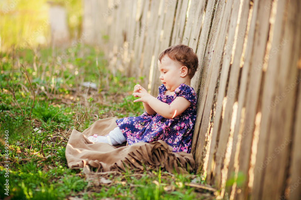 the little girl sits about a fence the little girl sits about a fence