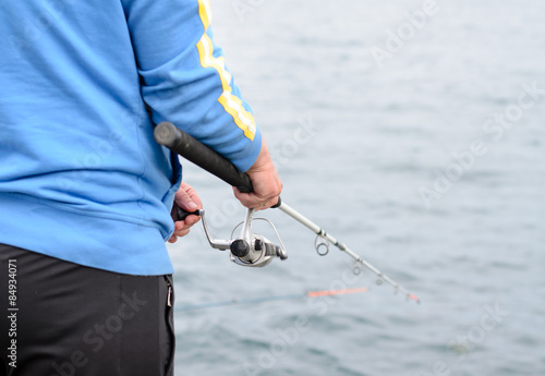 Man standing fishing at the seaside