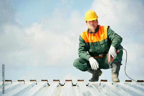 Worker builder roofer at metal profile work photo