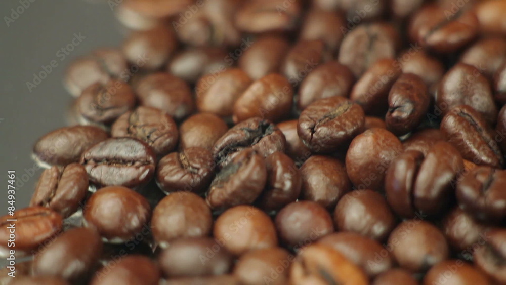 Roasted coffee beans rotates on the table. close-up Roasted coffee beans rotates on the table. close-up