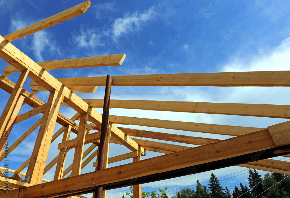 Installation of wooden beams at construction of the frame house Installation of wooden beams at construction of the frame house