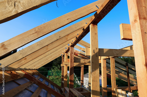 Installation of wooden beams at construction of the frame house photo