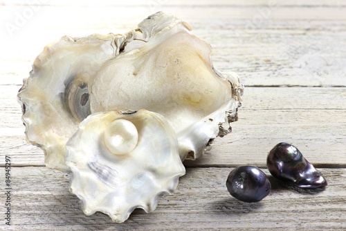 Austernschalen mit Perlen auf Holztisch