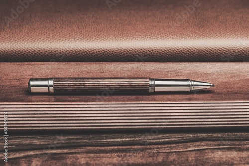 Luxurious rollerball pen on a wooden background photo