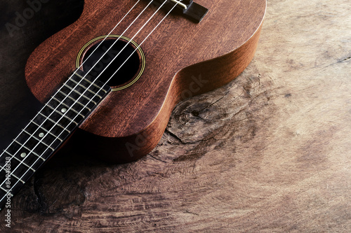 Close up of ukulele on old wood background with soft light photo