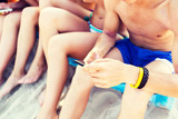 close up of friends with smartphones on beach
