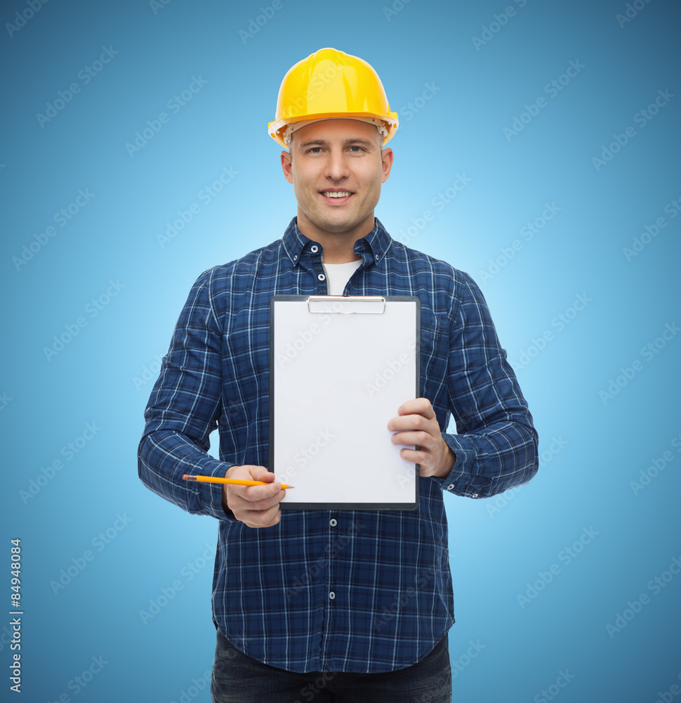 smiling male builder in helmet with clipboard smiling male builder in helmet with clipboard