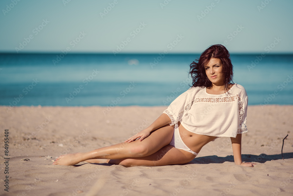 Young woman relaxing on the beach near the sea
