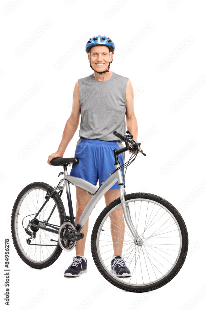 Fototapeta premium Senior biker standing behind a bicycle and smiling