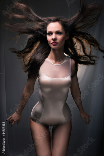 Sexy lady with waving hair in combidress posing indoors