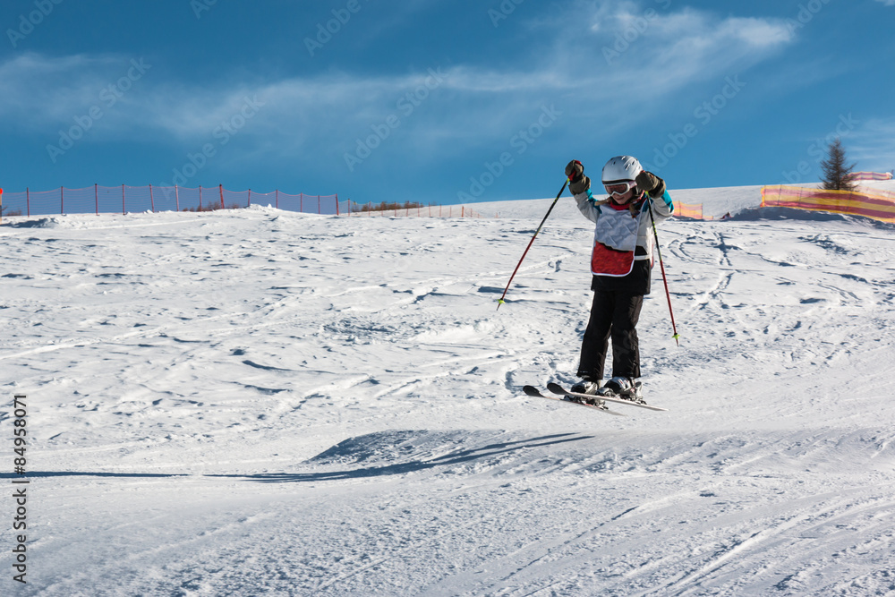 Little skier performs jump in the snow Little skier performs jump in the snow