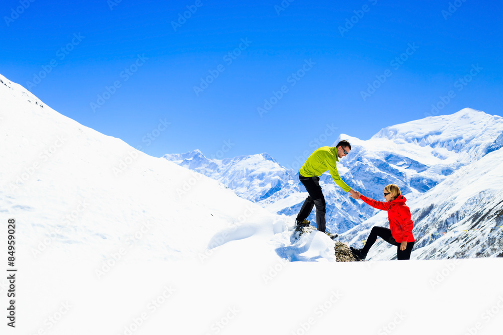 Helping hand couple hikers in mountains