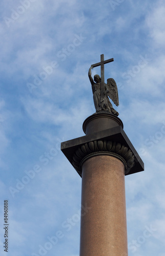 Angel with cross against cloudy blue sky