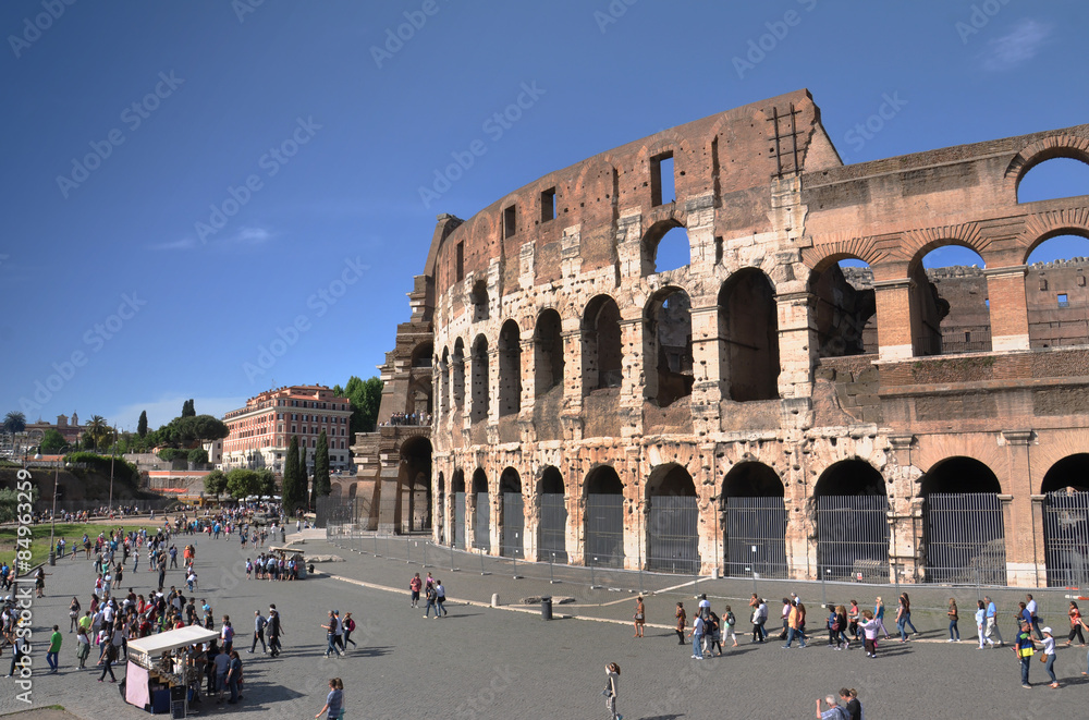 Tourists walk next to The Coliseum