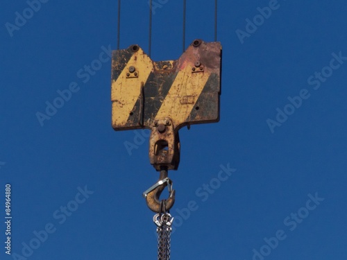 Haken an der Umlenkrolle eines alten Kran vor blauem Himmel im Sonnenschein auf einer Baustelle in Oerlinghausen bei Bielefeld am Hermannsweg im Teutoburger Wald in Ostwestfalen-Lippe photo