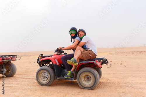 Young couple riding sand ATV