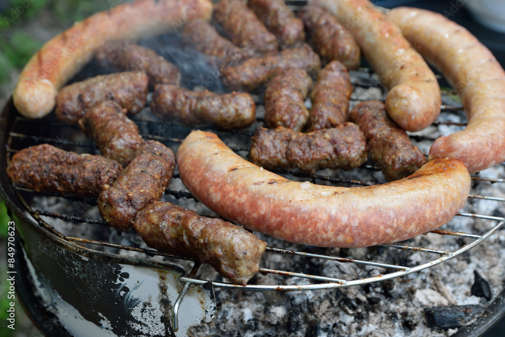 Traditional Romanian food, barbecue with grilled meat rolls, mititei or mici (beef, pork and lamb meat) and sausages Traditional Romanian food, barbecue with grilled meat rolls, mititei or mici (beef, pork and lamb meat) and sausages