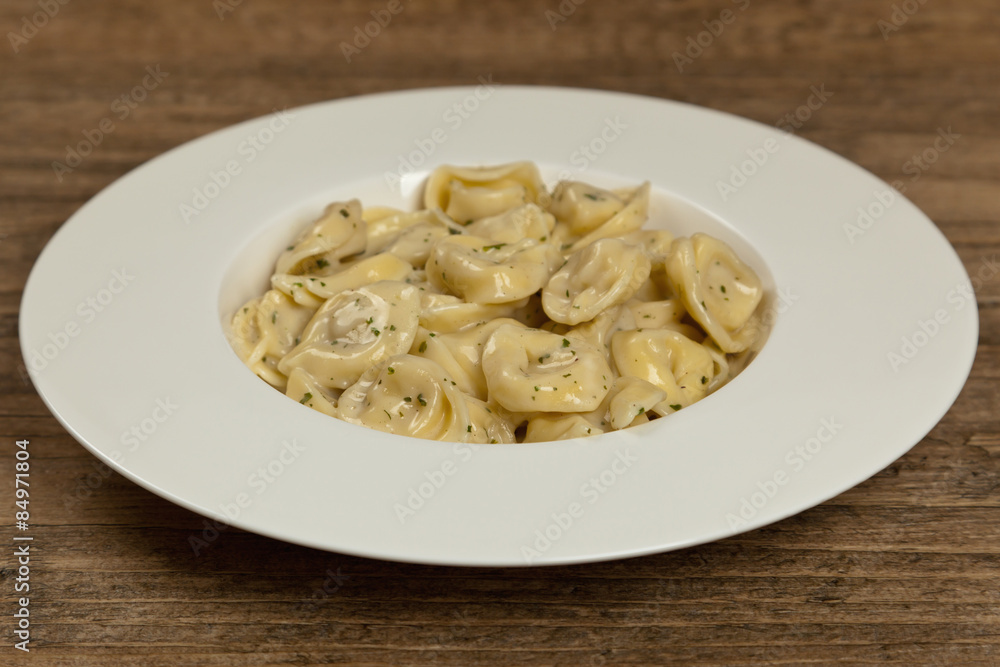 Italian Tortellini Pasta with Alfredo Sauce and Basil. Selective focus.