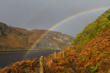 Rainbow over autumn fall water hills and mountains.