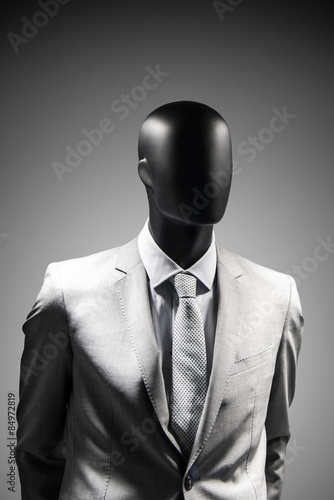 Fashion mannequin in elegant suit over dark grey background. Black White photo